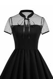 Høy hals med svarte prikker: En linje 1950-talls kjole