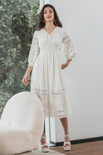 Te-lengde blonder liten hvit kjole med lange ermer